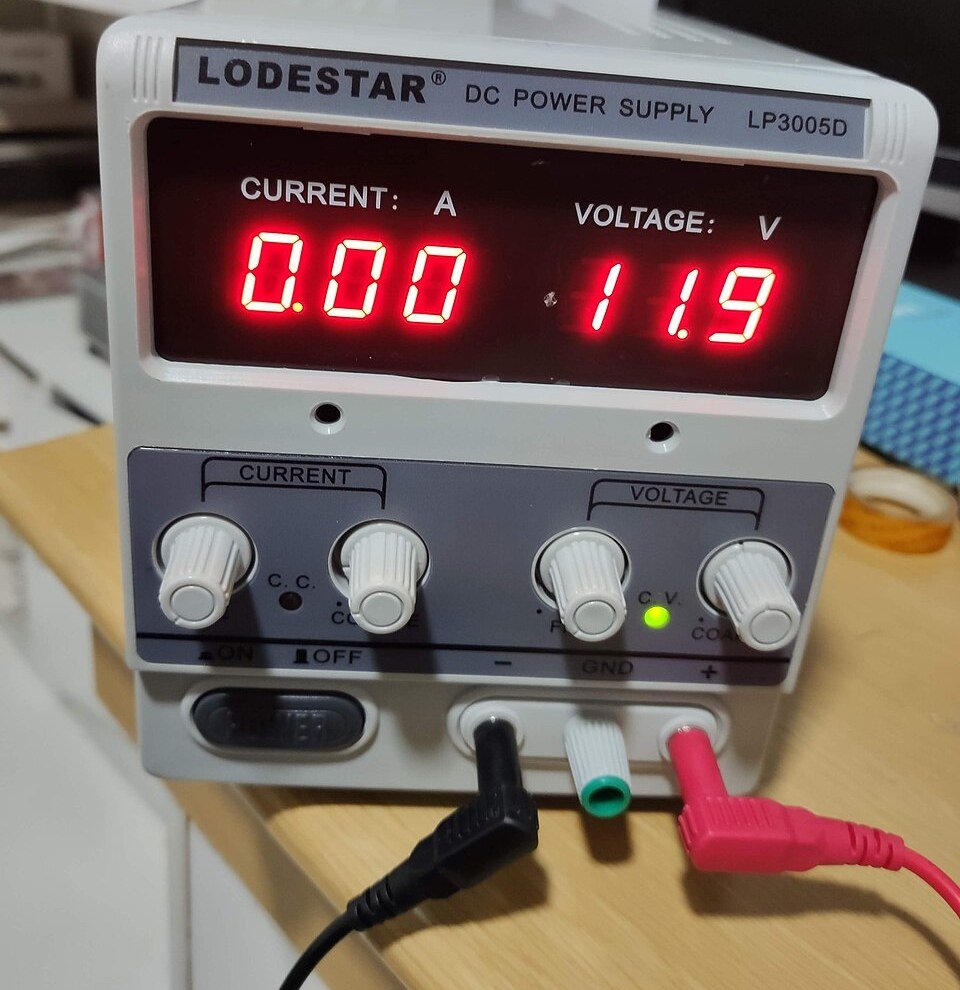 A real bench DC power supply with red 7-segment LED voltage and current readouts
